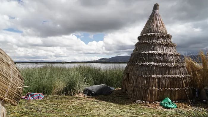 Visitors holding paddles up on a floating Uros island