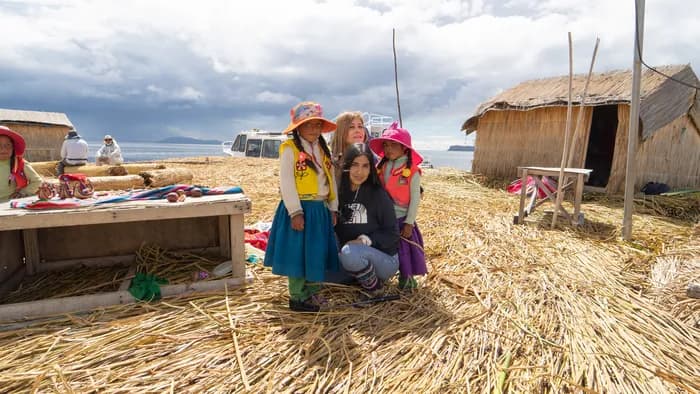 Visitors holding paddles up on a floating Uros island