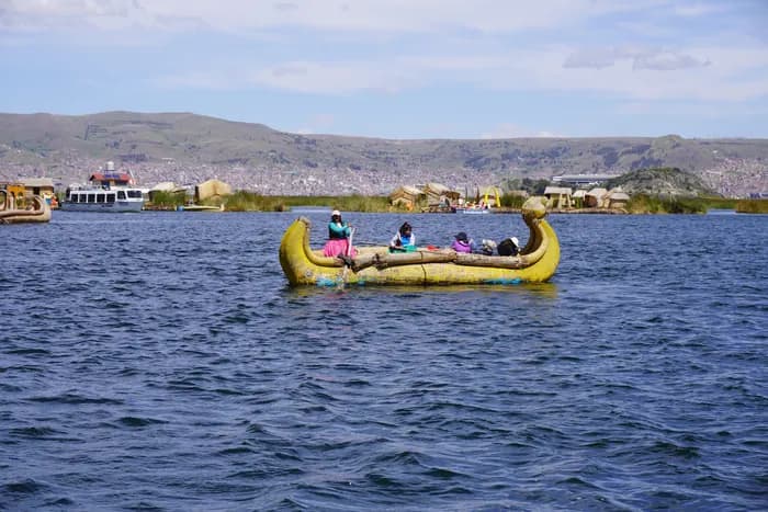 Visitors holding paddles up on a floating Uros island