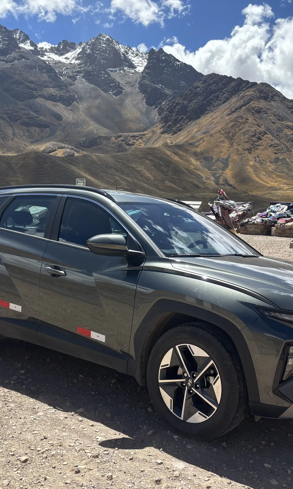 Private vehicle on the altiplano with snow-capped volcanoes behind