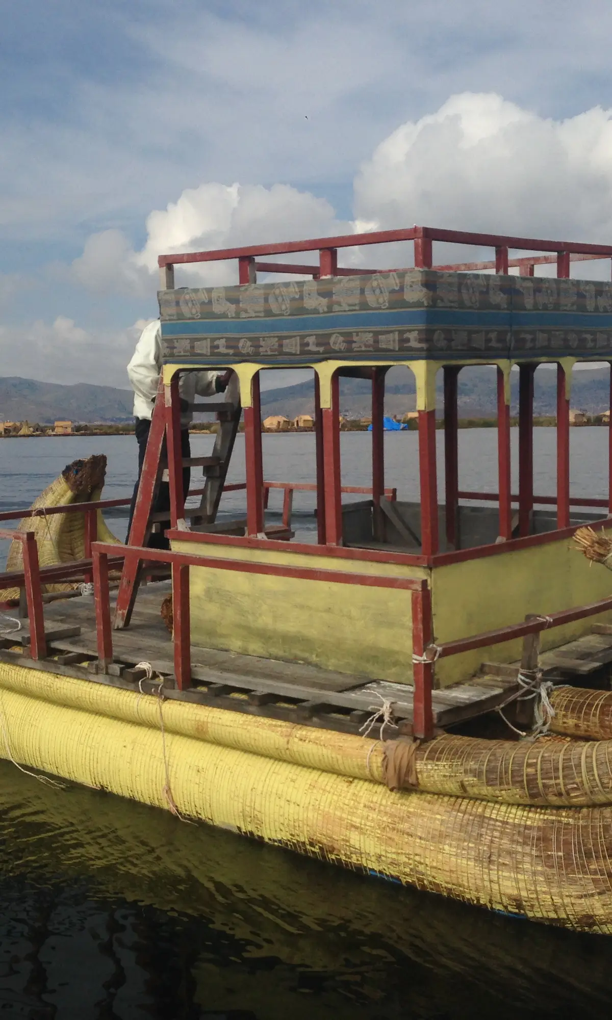 Reed boat sailing past the floating islands of the Uros